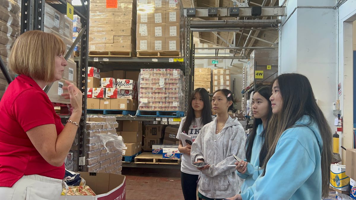 The project team learning about warehouse inventory operations from food-bank staff